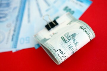 United Arab Emirates dirham money bills in big amount on red. Finance and banking concept