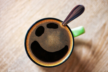 Pareidolia cup of black coffee with funny grin