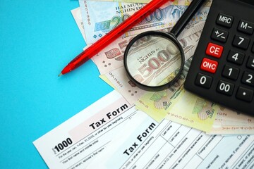 Vietnamese dong money bills and calculator with tax form on blue. Taxation and accounting concept