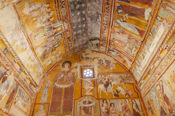 View of ancient frescoes burst with vibrant colors, telling stories across the vaulted ceilings and walls of the old church, Bominaco, Abruzzo, Italy.