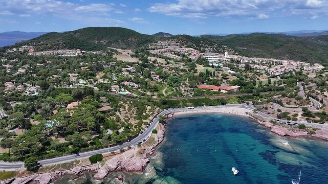aerial view,  flying along Agay Bay coastline, French Riviera (C&ocirc;te d'Azur) towards "Plage du Pourrousset"  with left panning from Village Cap Est&eacute;rel in Saint-Rapha&euml;l to Cap Dramont - 4k footage 