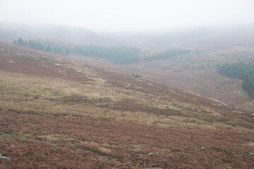 Mist descends and obscures the landscape on a foggy day in the Peak District