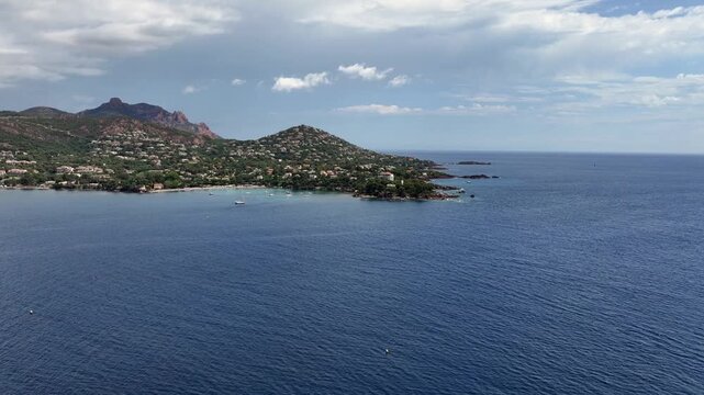 flying across Agay Bay, French Riviera (C&ocirc;te d'Azur) with left paning from "Phare d'Agay" along coastline to Beach  "Agay Plage" and  "Massif de l'Esterel" in background - 4k aerial video footage