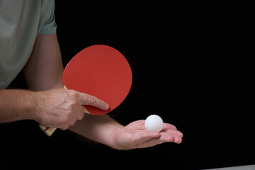 a man holding a ping pong paddle and a ball