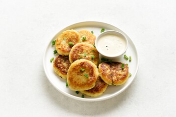 Potato pancakes made from mashed potato and green onion served with sauce