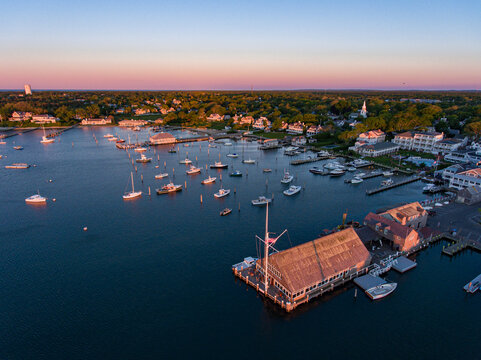 Aerial view of boats dotting the harbor under the pastel dawn sky, with the iconic building on the pier standing prominently, Martha's Vineyard, Massachusetts, United States.