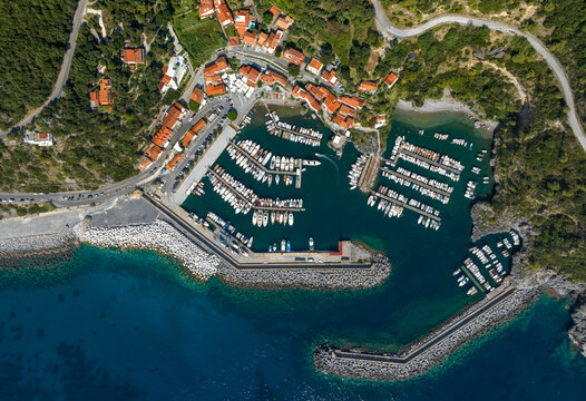 Perpendicular aerial view of the marina of Maratea, in the province of Potenza, Basilicata, Italy. It is a small port overlooking the Mediterranean Sea. There are many small boats anchored in the bay.