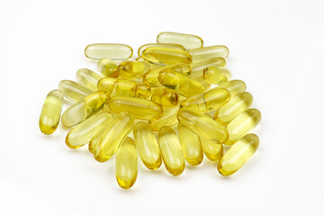 Pile of golden tablets fish oil omega vitamins capsules isolated on white background