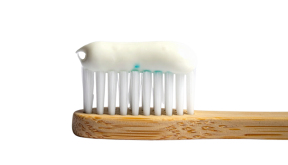 A toothbrush with toothpaste on it is isolated against a clean white background
