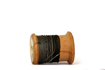 Old wooden bobbin of thread isolated on white