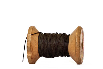 Old wooden bobbin of thread isolated on white