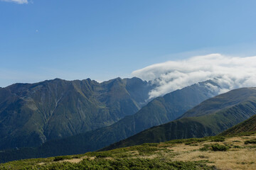 fagaras mountains ridge high mountain peaks on sunny day with big white clouds