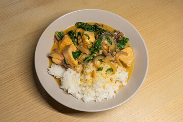 A plate of salmon coconut curry with rice.