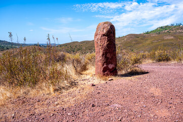 Megalithic menhir dos Gregorios standing stone in lush field megalithic monument on the Algarve Trail Portugal dirt path hiking trail Via Algarviana