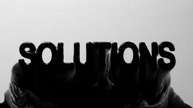 Detailed black ink spreads over white paper revealing the word SOLUTIONS, perfect for corporate titles or luma matte overlays