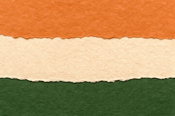 Torn paper layers in orange, cream, and green – textured abstract background