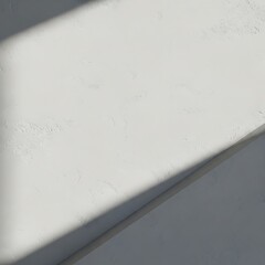 A minimalist backdrop with textured surface and dramatic shadows, showcasing a light and neutral color palette.
