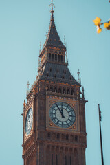Majestic big ben clock tower against blue sky and white clouds, a symbol of london and england