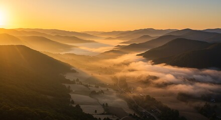 Sunrise over mountainous landscape with misty valleys and golden light