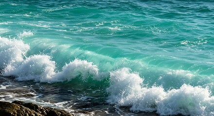 Fototapeta premium Turquoise ocean waves crashing against rocky shoreline