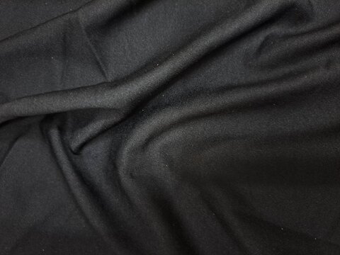 Luxurious black fabric with subtle pattern and elegant draping