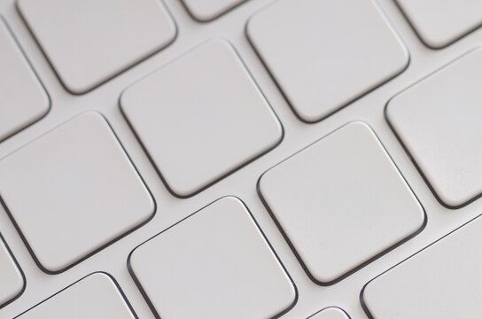 A sleek, modern keyboard with unlabeled white chiclet keys arranged in a perfect geometric grid, creating an abstract background for technology and design themes.