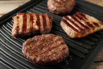 Delicious grilled beef meat on wooden table, closeup