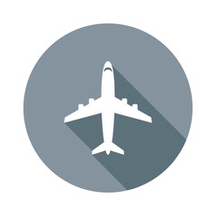 Sleek white airplane soars above casting a cool gray shadow on a round moody gray surface promising flights and global