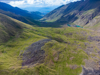 Aerial drone shot of mountains, valley, and glacial moraine in the high mountains of Kyrgyzstan.