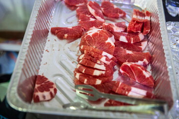 Grapefruit slices with tongs on an aluminum tray