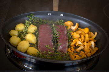 healthy lifestyle - roasted filet from venison, chanterelles with cranberries and potatoes, with fresh herbs out the garden for a delicious meal