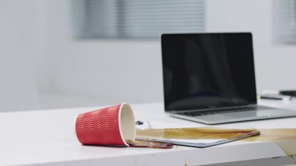 Business professional with coffee cup at desk working on laptop in modern office - Powered by Adobe