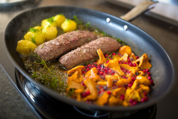 healthy lifestyle - roasted filet from venison, chanterelles with cranberries and potatoes, with fresh herbs out the garden for a delicious meal