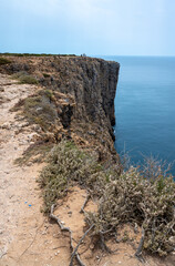 Majestic cliffs on Algarve hiking trail Via Algarviana at Cape Sao Vincente tower over Atlantic ocean on Portuguese Algarve coast