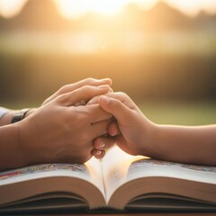 Heartwarming moment of a parent and child holding hands over an open book at golden hour
