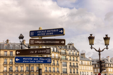 panneaux de signalisation &agrave; Paris avec des immeubles haussmaniens typique de Paris en arri&egrave;re plan. Les panneaux indiquent : Notre Dame et Ile Saint Louis