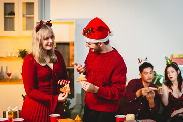 A cheerful group of diverse friends gathers around a decorated Christmas tree, exchanging gifts with laughter and joy at a festive holiday party.