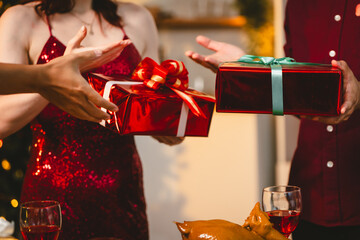 A cheerful group of diverse friends gathers around a decorated Christmas tree, exchanging gifts with laughter and joy at a festive holiday party.