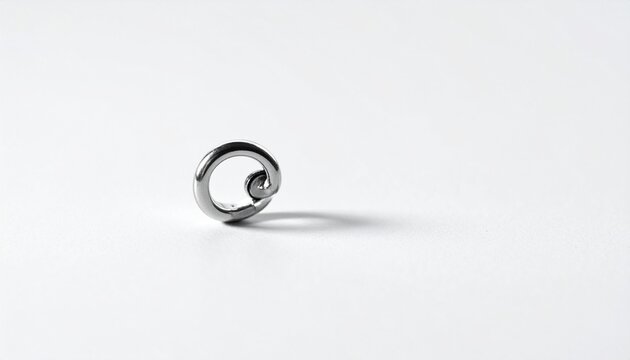 Single metallic spiral body piercing ring with a small bead, isolated on a plain white studio background