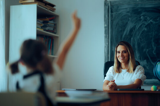 Teacher Happy That a Student Raises Hand Wanting to Answer. Primary schoolchild communicating in class with her professor 

