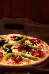 Green and kalamata olives and feta cheese on rustic wooden background. Soft focus.	