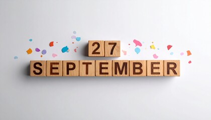 Wooden Blocks with Date 27 September. Calendar for birthday or anniversary on solid colored background with confetti