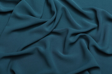 Soft lightweight flowy georgette fabric in teal blue, elegantly draped with natural folds. Perfect for fashion design, textiles, sewing, dressmaking, and delicate feminine style concepts.