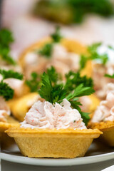 Close-up of gourmet tartlets filled with creamy seafood salad, garnished with parsley. Golden crust, soft filling, shallow depth of field. Ideal for culinary and food photography themes.