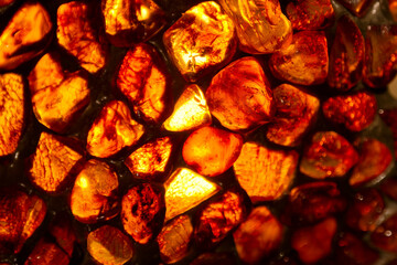 Vivid amber stones illuminated by light showcasing unique textures and colors