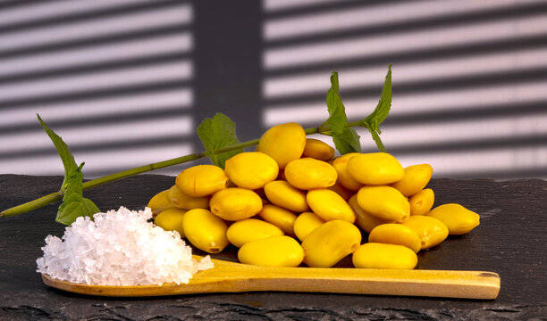 altramuces ali&ntilde;ados con una cuchara de madera con sal y rama de menta fresca