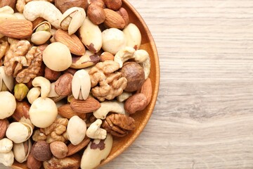 Mix of different nuts on wooden table, top view. Space for text