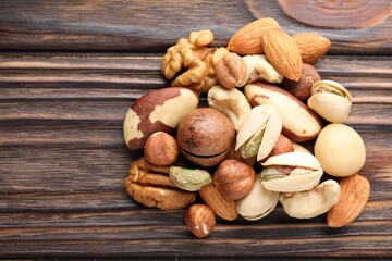 Mix of different nuts on wooden table, top view. Space for text