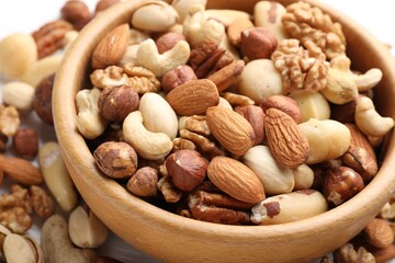 Mix of different nuts in bowl on table, closeup