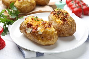 Tasty stuffed baked potatoes on white wooden table, closeup